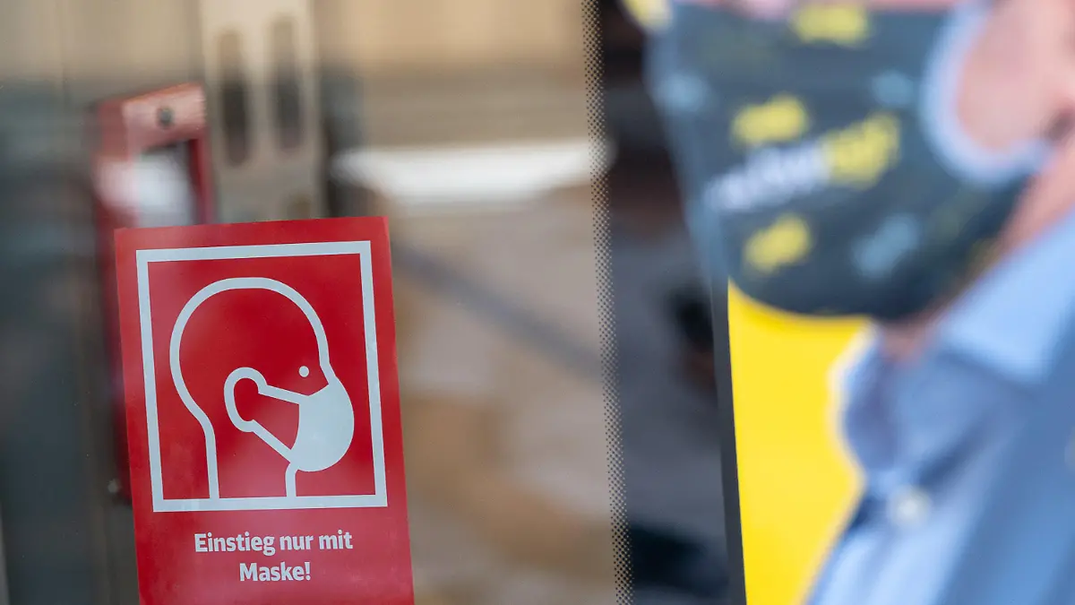 07.08.2020, Baden-Württemberg, Stuttgart: Ein Hinweise "Einstieg nur mit Maske" hängt während eines Pressetermins, bei dem die neuen neue Hinweistafeln zur Maskenpflicht in Zügen und Bahnhöfen vorgestellt werden, hinter Winfried Hermann (Bündnis 90/Die Grünen), Verkehrsminister von Baden-Württemberg. Foto: Sebastian Gollnow/dpa +++ dpa-Bildfunk +++