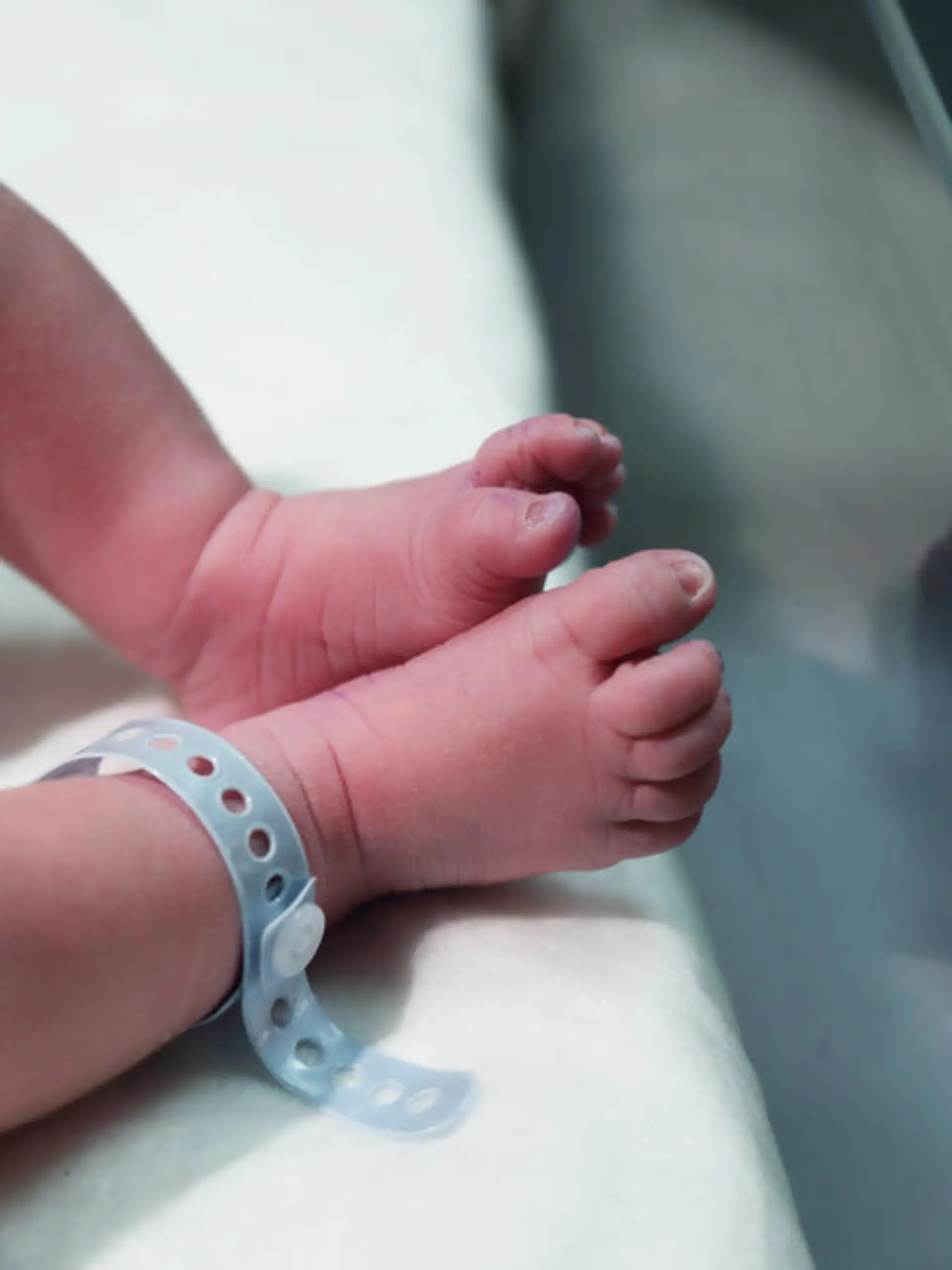 Babyfüße im Krankenhaus mit Geburtsbändchen