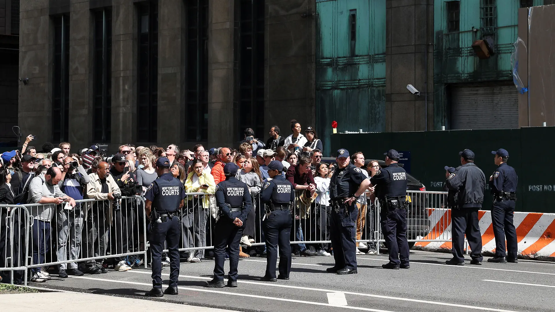 Law enforcement officers stand guard as people gather outside Manhattan Criminal Courthouse on the day of former U.S. President Donald Trump's planned court appearance after his indictment by a Manhattan grand jury following a probe into hush money paid to porn star Stormy Daniels, in New York City, U.S., April 4, 2023. REUTERS/Caitlin Ochs