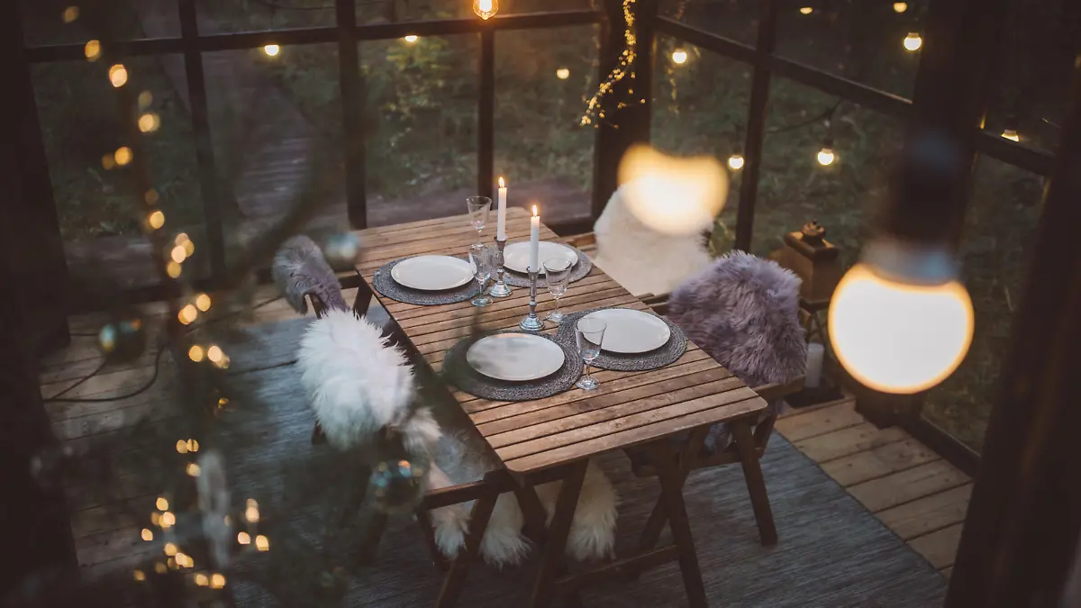 Table at cottage green house decorated for Christmas dinner.