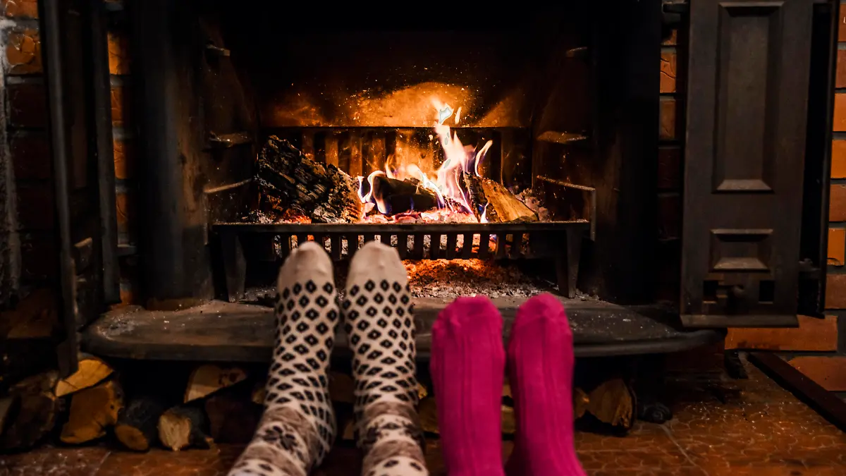 Feet in wool socks warming by cozy fire