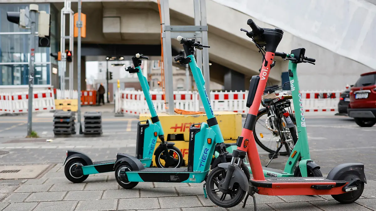PRODUKTION - 05.03.2023, Bayern, Nürnberg: E-Scooter stehen in der Fürther Straße in der Nähe des U-Bahnhofs Muggenhof. Etwa 6000 Elektro-Tretroller von fünf Anbietern sind in Nürnberg unterwegs - und können nach der Fahrt einfach irgendwo am Ziel abgestellt werden. Dem schiebt Bayerns zweitgrößte Stadt nun einen Riegel vor. (Zu dpa: "Abstellchaos bei E-Scootern - ein Ende in Sicht?") Foto: Daniel Löb/dpa +++ dpa-Bildfunk +++