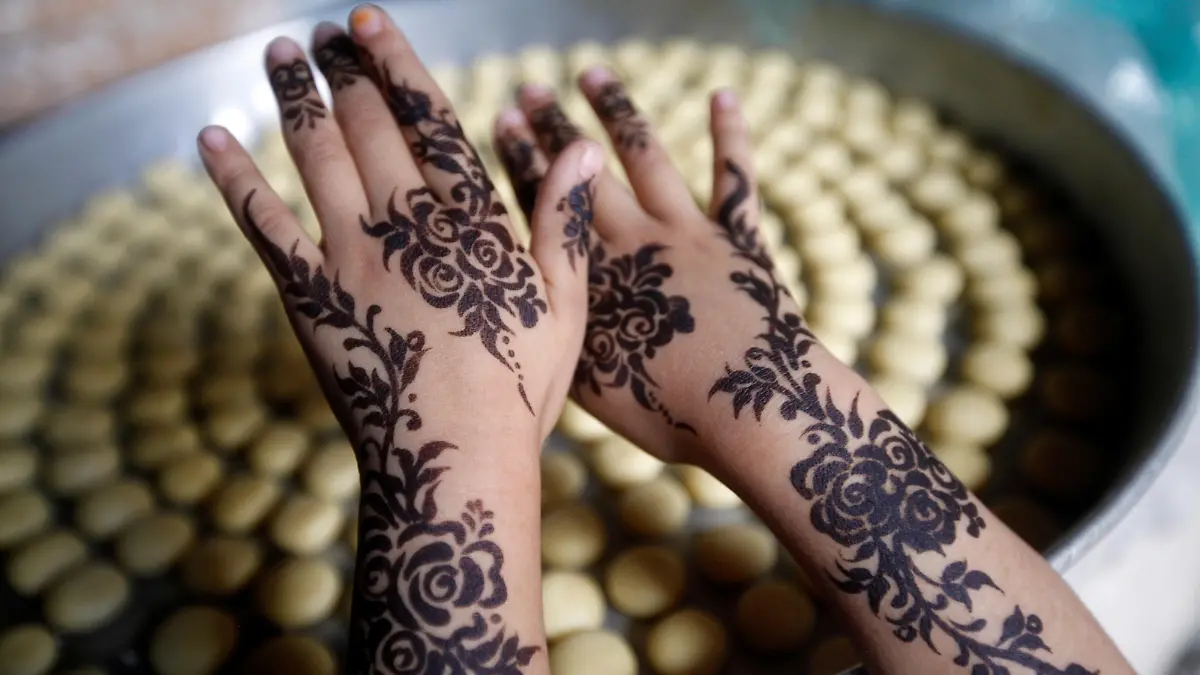 A girl displays a henna pattern applied on her hands for the Eid al-Adha festival at the old quarter of Sanaa, Yemen July 30, 2020. REUTERS/Mohamed al-Sayaghi