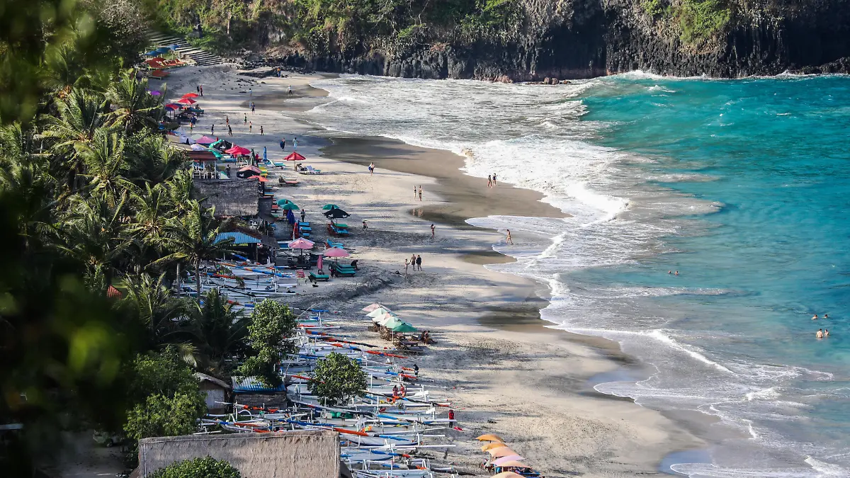 People enjoy at the beach in Candidasa, Bali, Indonesia, on September 1, 2022. (Photo by Garry Lotulung/NurPhoto)