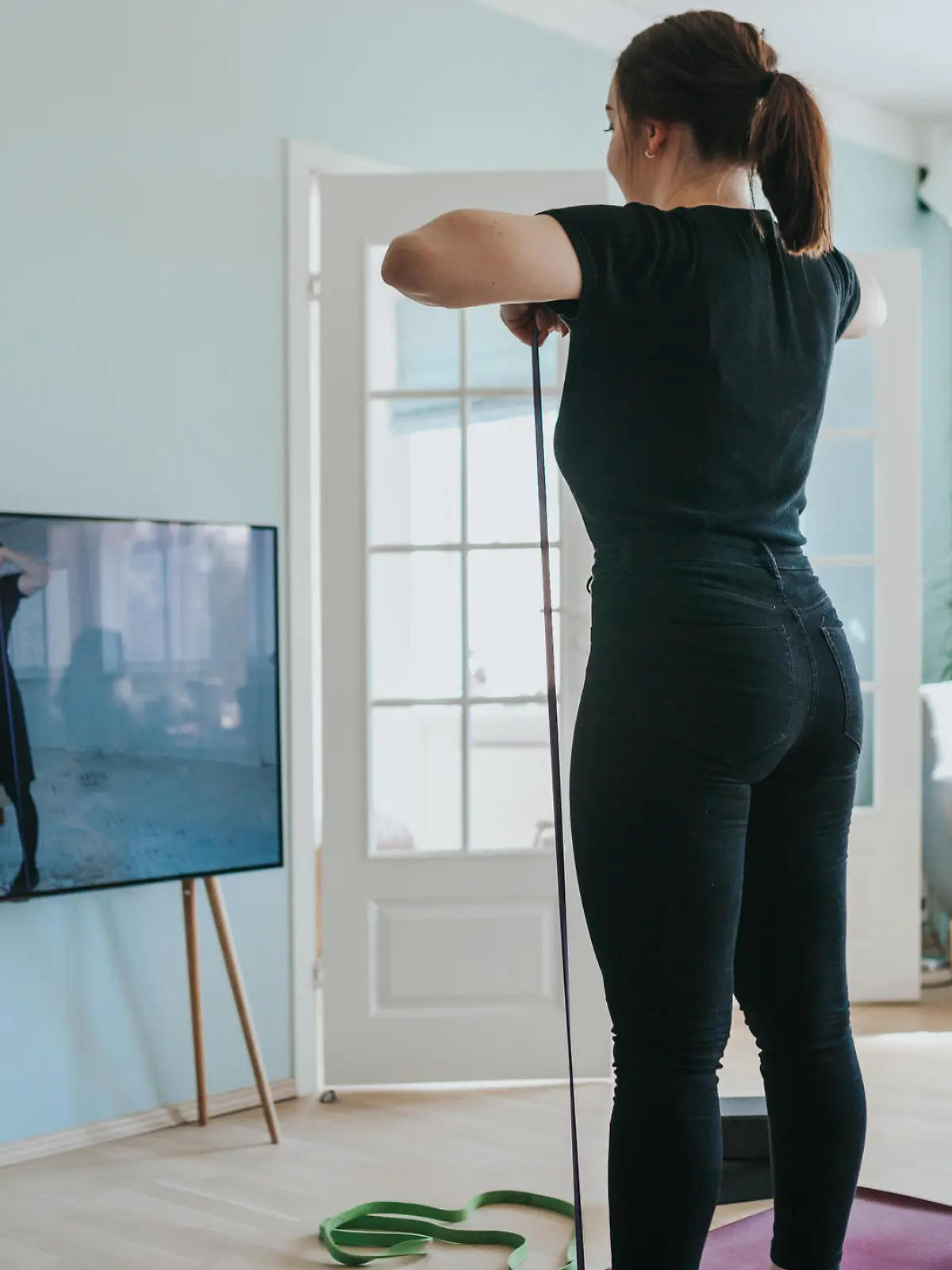 Frau trainiert vor dem Fernseher