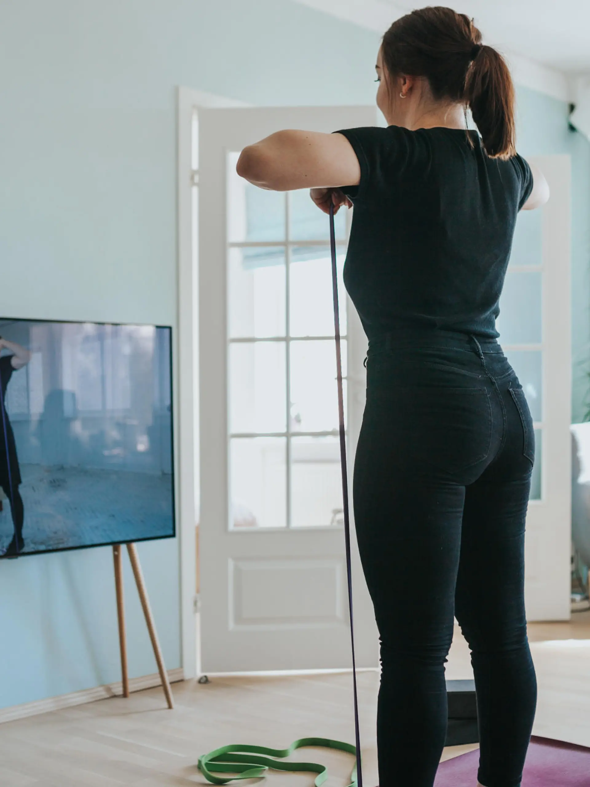 Frau trainiert vor dem Fernseher