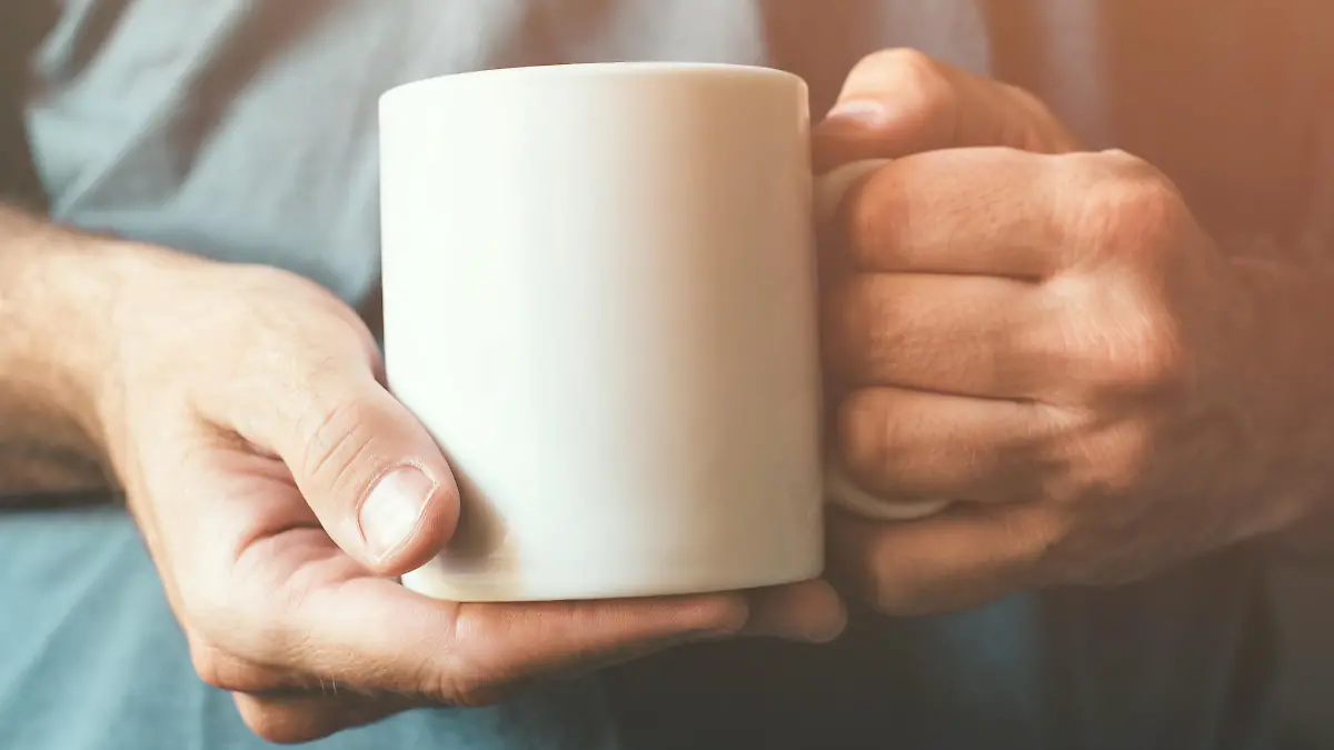 Ein Mann hält eine Kaffeetasse