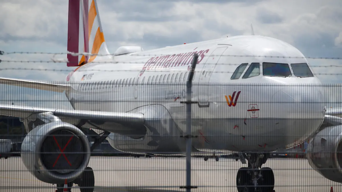 A parked plane of the German airline Eurowings is seen behind a fence, amid the spread of the coronavirus disease (COVID-19) at the Cologne-Bonn Airport in Cologne, July 28, 2020. REUTERS/Wolfgang Rattay
