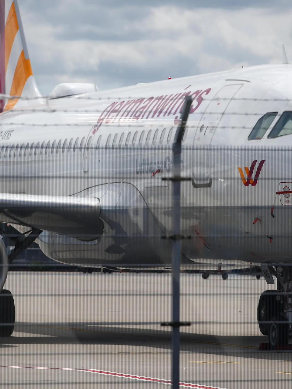 A parked plane of the German airline Eurowings is seen behind a fence, amid the spread of the coronavirus disease (COVID-19) at the Cologne-Bonn Airport in Cologne, July 28, 2020.  REUTERS/Wolfgang Rattay