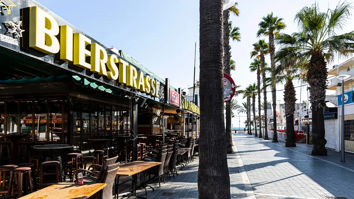 SPANIEN, MALLORCA, PALMA DE MALLORCA, 07.08.2020 - Die Lokalität Las Palmeras links in der sogenannten Bierstraße an der Playa de Palma, die aufgrund einer Verfügung der Balearen-Regierung bezüglich der Corona-Pandemie aktuell geschlossen ist. Eine Person läuft durch die Straße. Der Schriftzug Bierstrasse hängt an der Vorderseite der Bar. *** SPAIN, MALLORCA, PALMA DE MALLORCA, 07 08 2020 The location Las Palmeras on the left in the so-called beer street in Playa de Palma, which is currently closed due to a decree of the Balearic Islands government regarding the Corona Pandemic A person walks through the street The lettering Bierstrasse hangs at the front of the bar