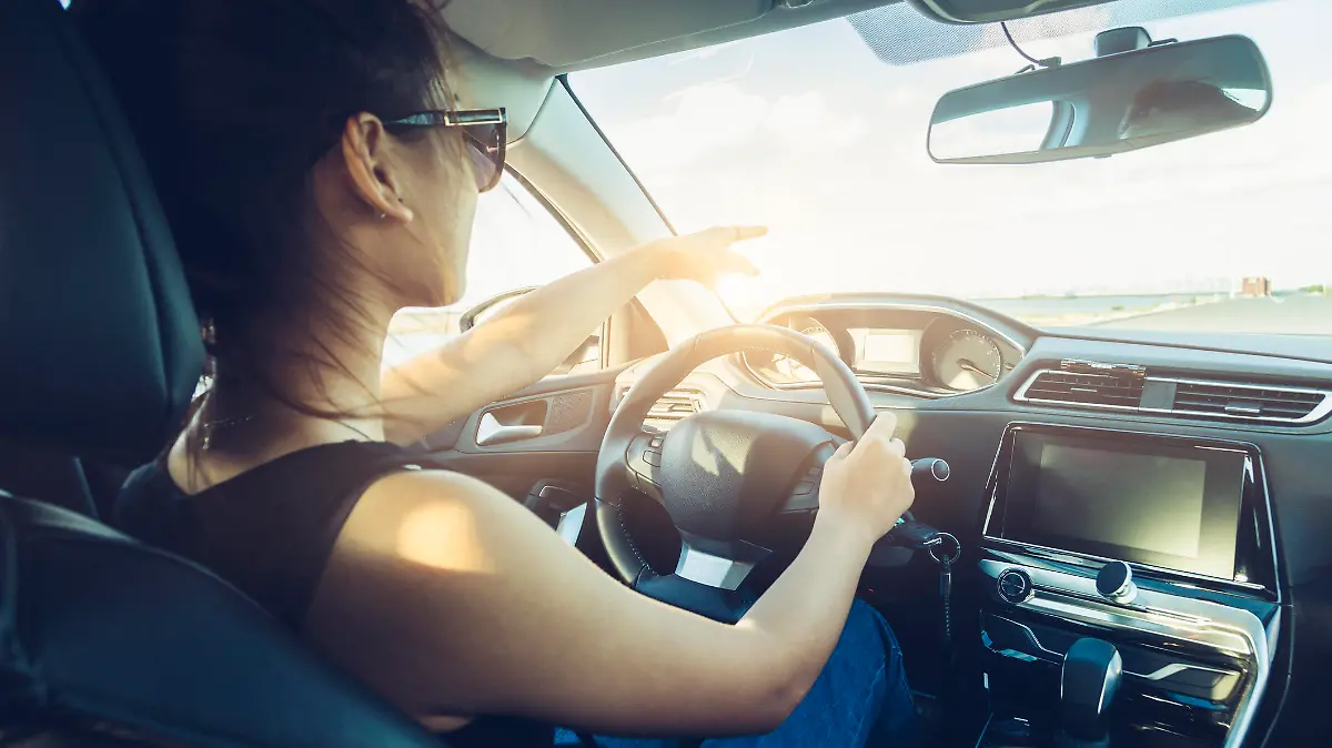 rear view of cool girl in sunglasses driving car.