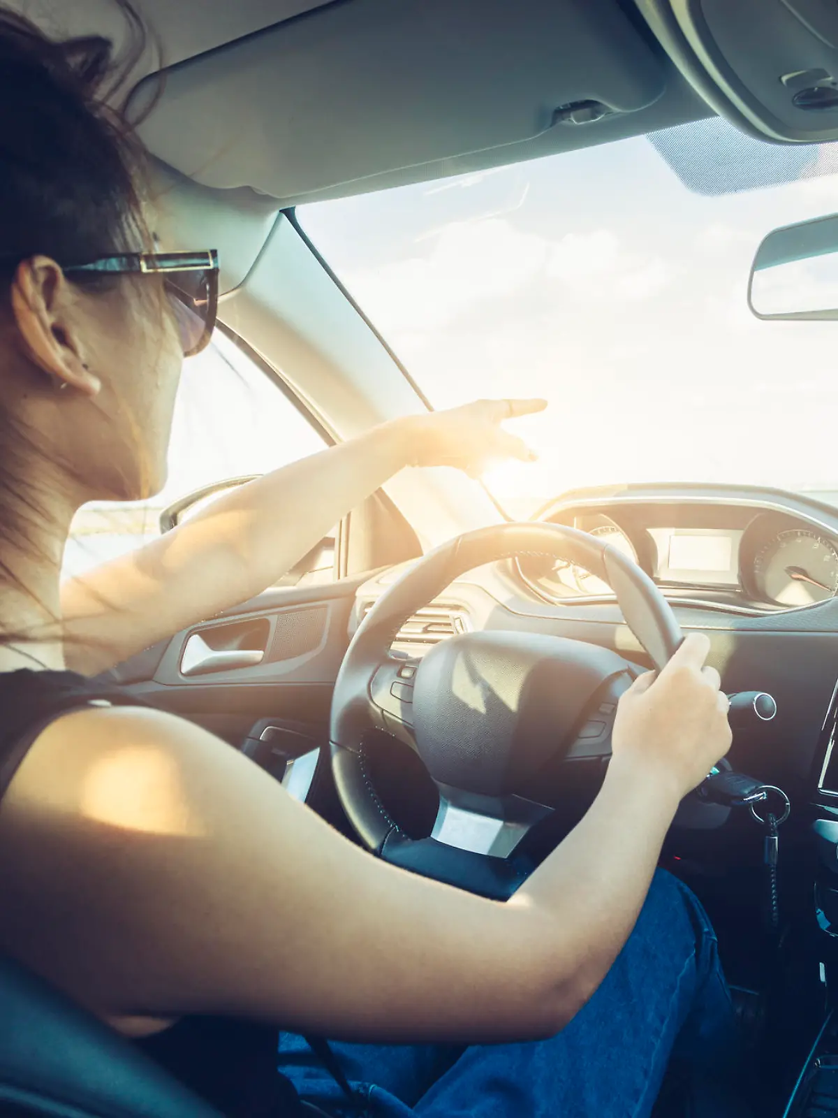 rear view of cool girl in sunglasses driving car.