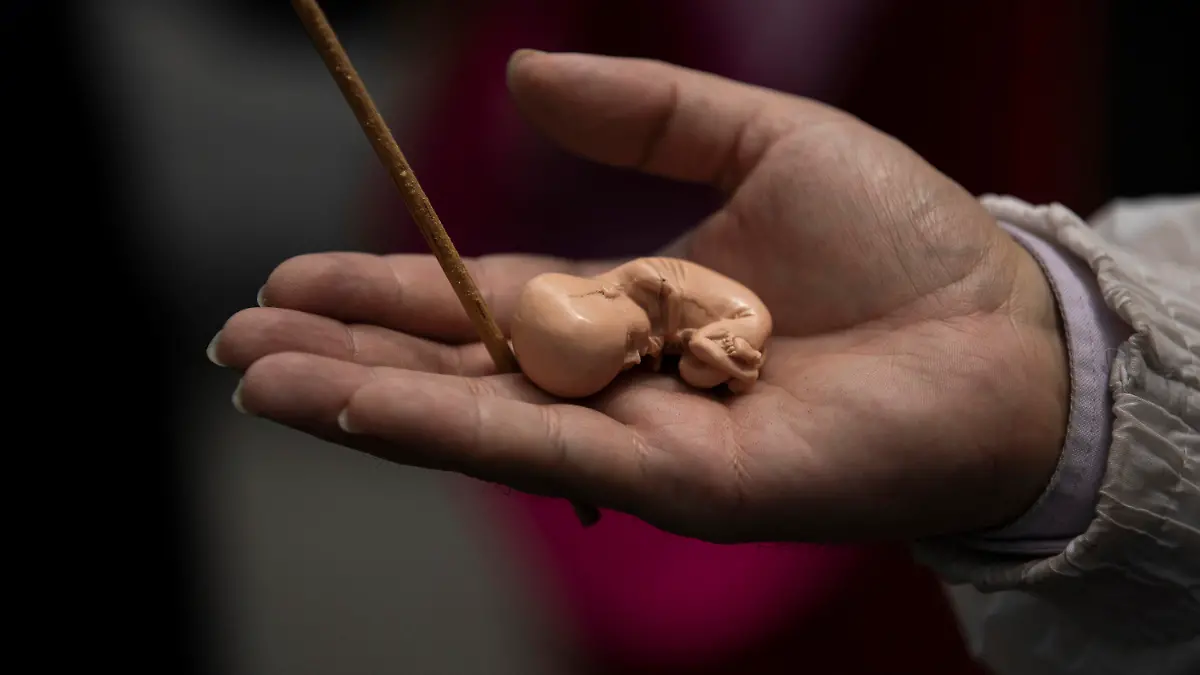 An activists against abortion holds a model of a fetus outside of Mexico's Supreme Court steps during a protest in Mexico City, Tuesday, July 28, 2020. The activists protest as Mexico's Supreme Court is expected to rule on a case regarding a Veracruz state law prohibiting abortion except in cases of rape, if the mother's life is in danger, or if the unborn baby is malformed. (AP Photo/Fernando Llano)