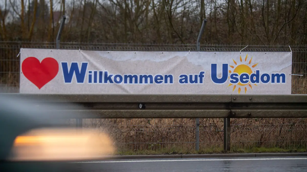 01.04.2023, Mecklenburg-Vorpommern, Altefähr: Ein Plakat mit dem Schriftzug "Willkommen auf Usedom" hängt an der B 96 auf der Insel Rügen. Für Verwirrung bei dem einen oder anderen Autofahrer dürfte ein Aprilscherz auf Rügen und Usedom gesorgt haben. An Zufahrten zu den Inseln waren zuletzt Banner zu sehen, die Ankommenden mit vertauschten Ortsangaben begrüßten. So war am Samstagmorgen hinter der Rügenbrücke "Willkommen auf Usedom" zu lesen. Foto: Stefan Sauer/dpa +++ dpa-Bildfunk +++