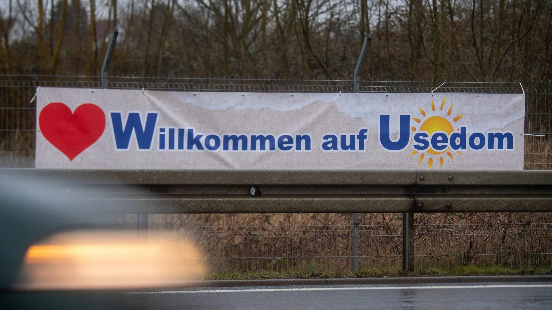 01.04.2023, Mecklenburg-Vorpommern, Altefähr: Ein Plakat mit dem Schriftzug "Willkommen auf Usedom" hängt an der B 96 auf der Insel Rügen. Für Verwirrung bei dem einen oder anderen Autofahrer dürfte ein Aprilscherz auf Rügen und Usedom gesorgt haben. An Zufahrten zu den Inseln waren zuletzt Banner zu sehen, die Ankommenden mit vertauschten Ortsangaben begrüßten. So war am Samstagmorgen hinter der Rügenbrücke "Willkommen auf Usedom" zu lesen. Foto: Stefan Sauer/dpa +++ dpa-Bildfunk +++