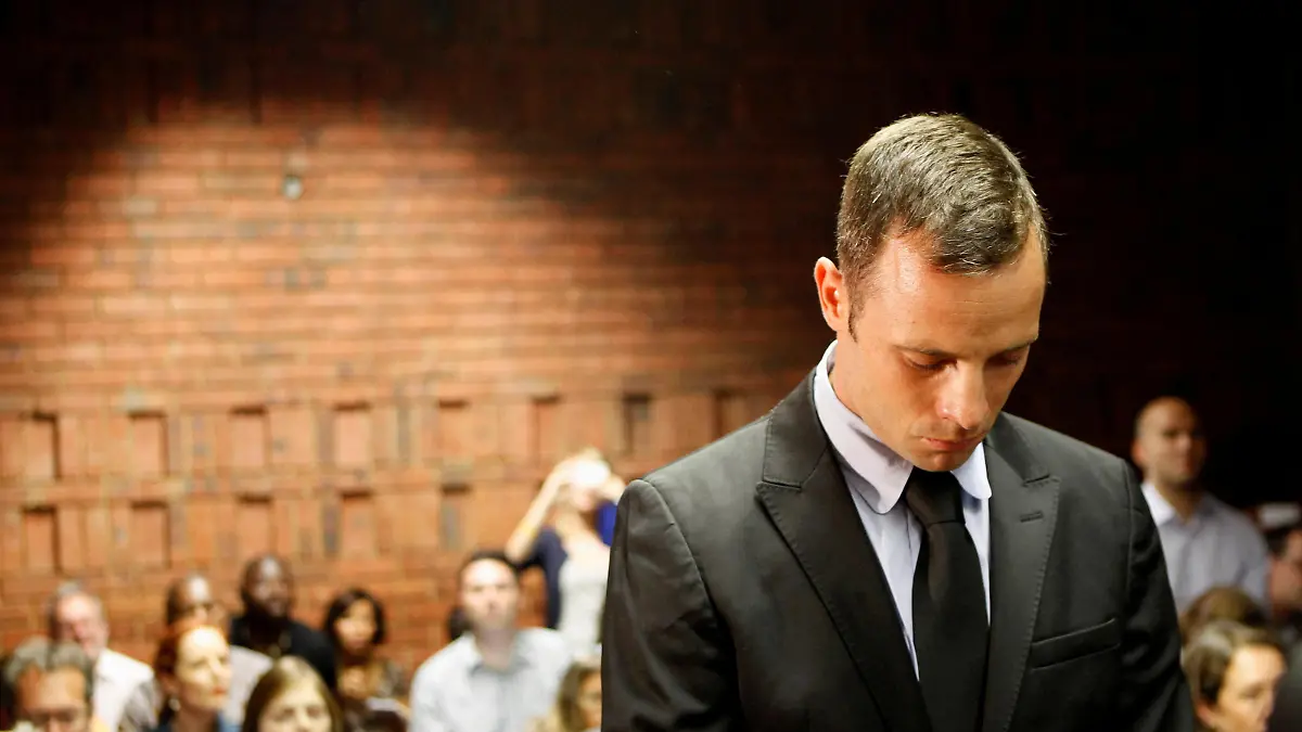 FILE PHOTO: Oscar Pistorius stands in the dock during a break in court proceedings at the Pretoria Magistrates court, February 20, 2013. REUTERS/Siphiwe Sibeko/File Photo