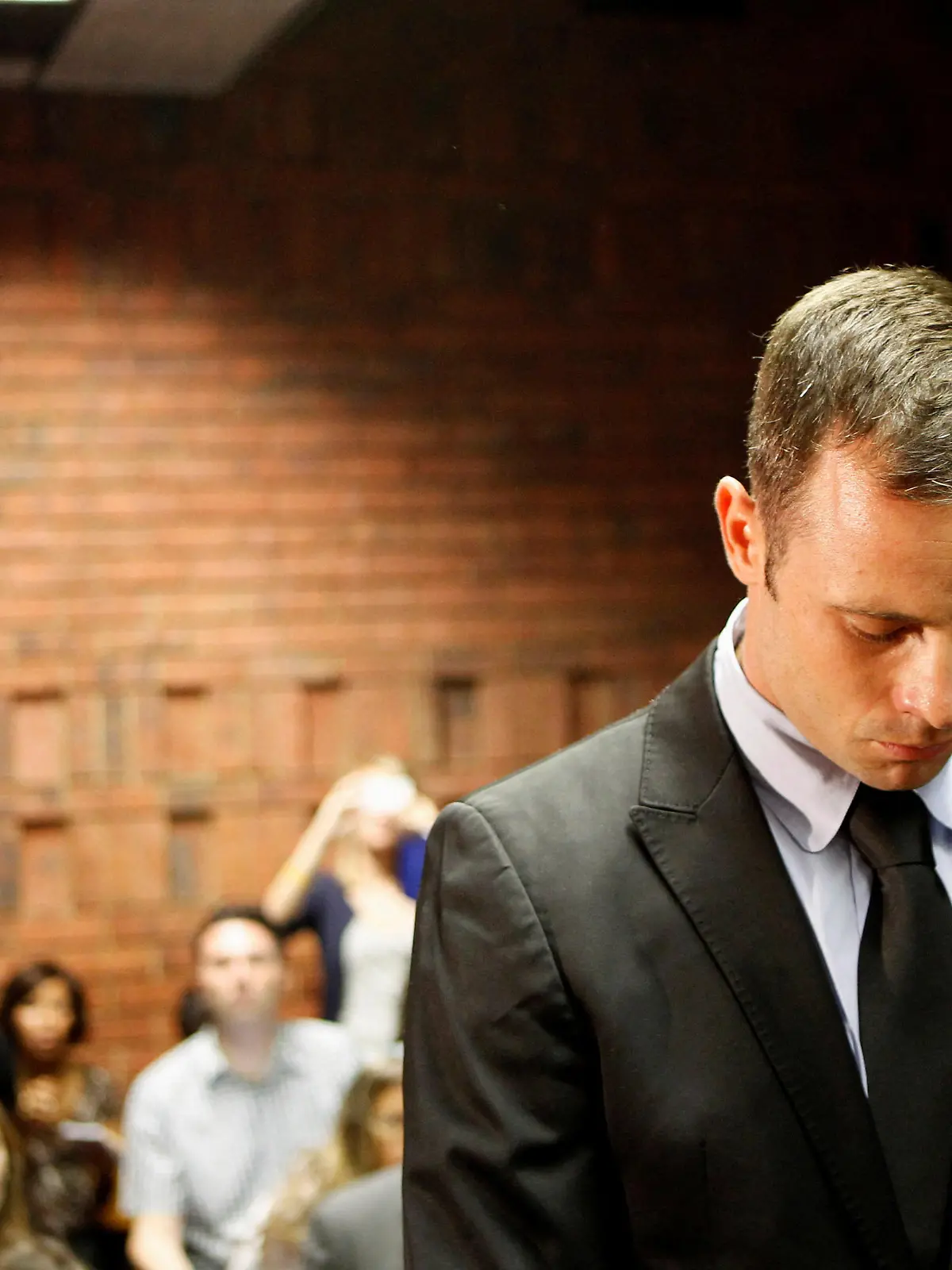 FILE PHOTO: Oscar Pistorius stands in the dock during a break in court proceedings at the Pretoria Magistrates court, February 20, 2013. REUTERS/Siphiwe Sibeko/File Photo