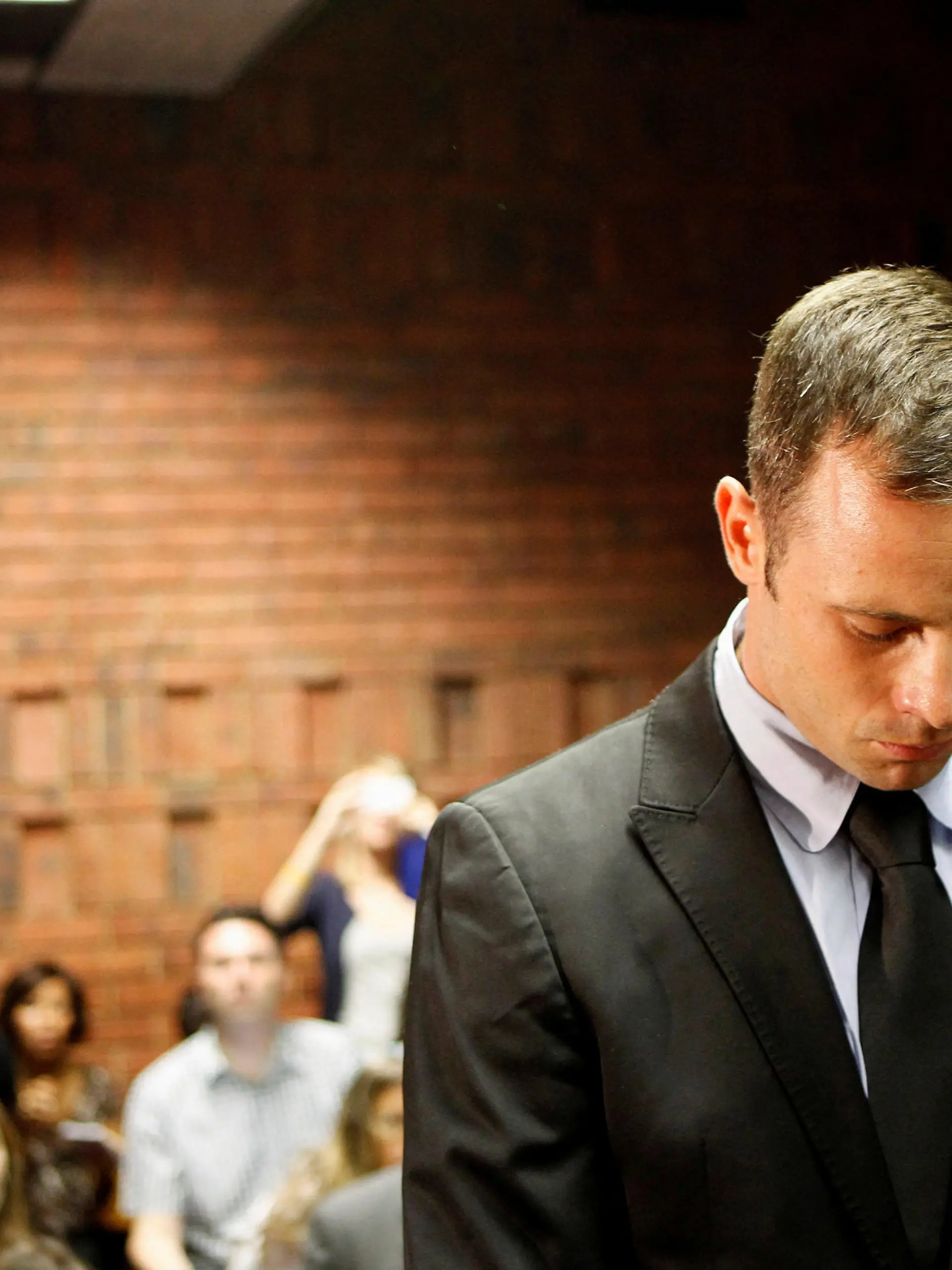 FILE PHOTO: Oscar Pistorius stands in the dock during a break in court proceedings at the Pretoria Magistrates court, February 20, 2013. REUTERS/Siphiwe Sibeko/File Photo