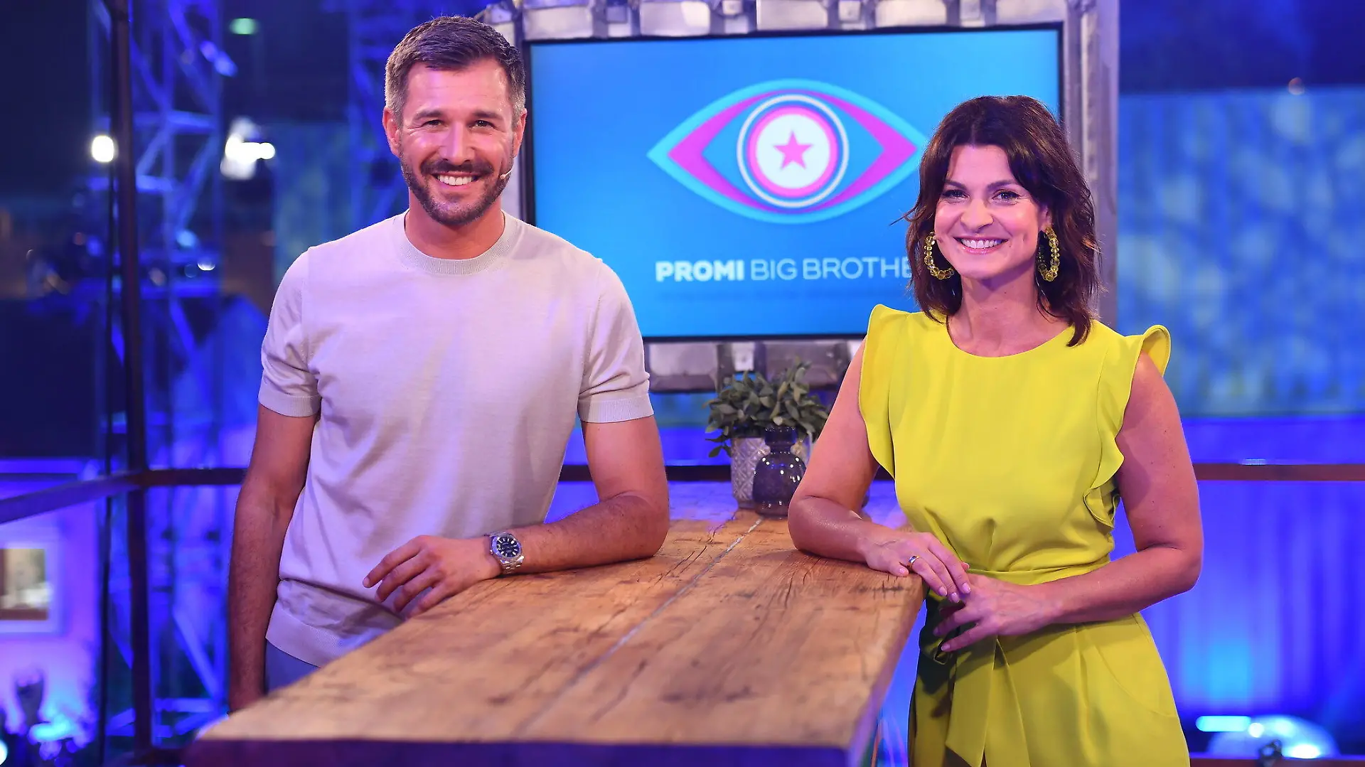 HANDOUT - 23.06.2020, ---: Die Moderatoren Jochen Schropp und Marlene Lufen stehen im Studio vor dem Logo der Sendung «Promi Big Brother". Am 07.08.2020 um 20.15 Uhr startet die neue Staffel der Show live bei Sat.1. Foto: Willi Weber/SAT.1/dpa - ACHTUNG: Das Foto darf nicht verändert und nur im vollen Ausschnitt verwendet werden. Keine Archivierung. Nur zur redaktionellen Verwendung im Zusammenhang mit einer Berichterstattung über die Sendung und nur mit vollständiger Nennung des Credits. +++ dpa-Bildfunk +++