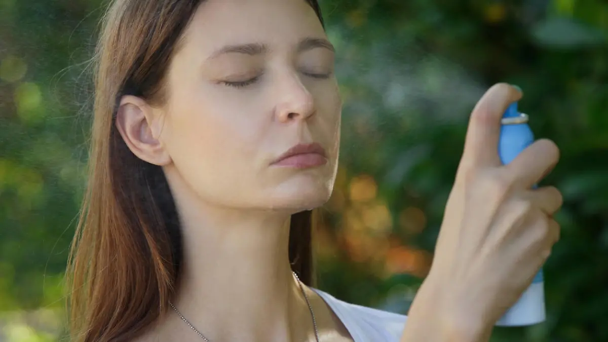 Frau benutzt Thermalwasser-Spray