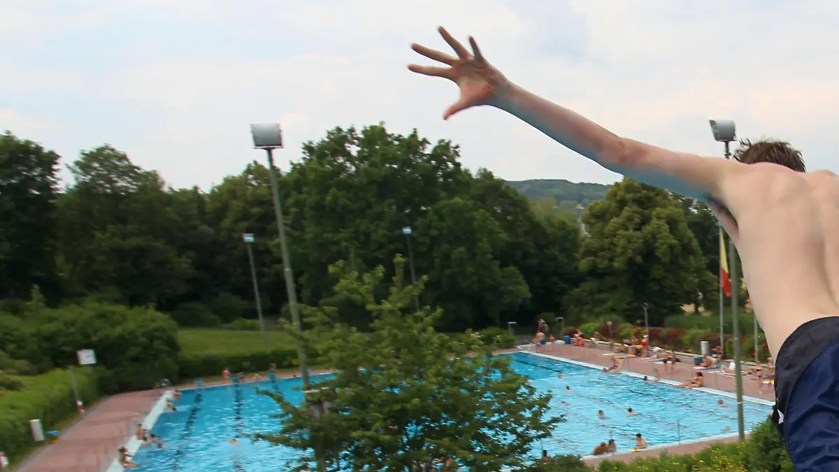 ARCHIV - Ein junger Mann springt am 29.06.2010 in einem Freibad in Würzburg (Unterfranken) vom Sprungturm. Trotz schlechter Wetteraussichten und etwa 15 Grad Celsius kaltem Wasser startet das Würzburger Freibad in diesem Jahr schon an Ostermontag in die Saison. (zu dpa «Würzburg startet schon am Ostermontag in die Freibad-Saison» vom 15.04.2017) Foto: Daniel Karmann/dpa +++(c) dpa - Bildfunk+++