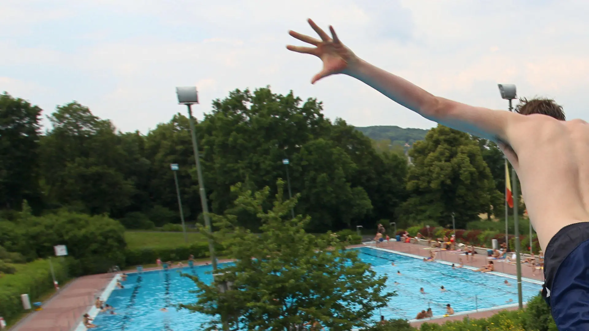 ARCHIV - Ein junger Mann springt am 29.06.2010 in einem Freibad in Würzburg (Unterfranken) vom Sprungturm. Trotz schlechter Wetteraussichten und etwa 15 Grad Celsius kaltem Wasser startet das Würzburger Freibad in diesem Jahr schon an Ostermontag in die Saison. (zu dpa «Würzburg startet schon am Ostermontag in die Freibad-Saison» vom 15.04.2017) Foto: Daniel Karmann/dpa +++(c) dpa - Bildfunk+++