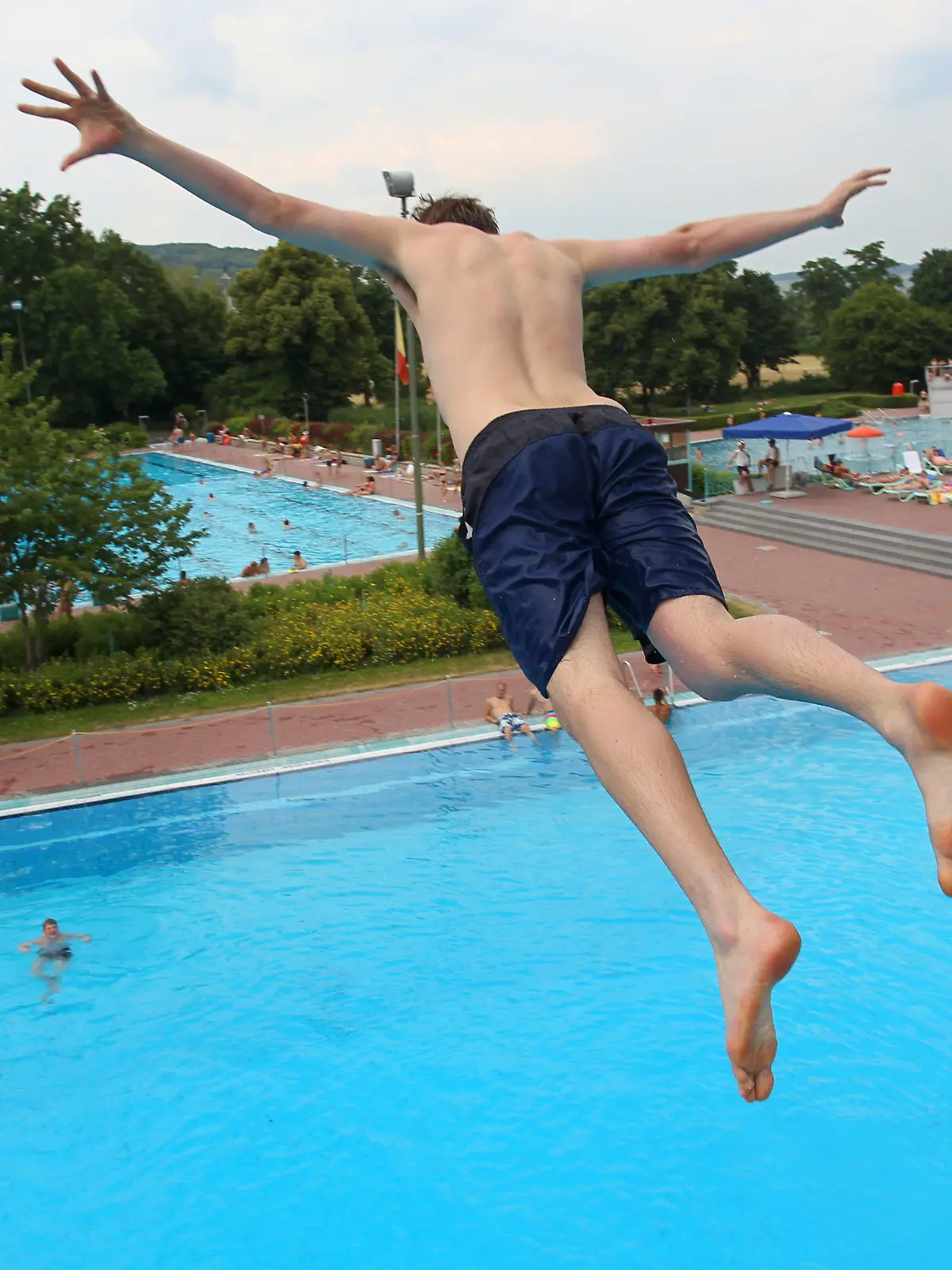 ARCHIV - Ein junger Mann springt am 29.06.2010 in einem Freibad in Würzburg (Unterfranken) vom Sprungturm. Trotz schlechter Wetteraussichten und etwa 15 Grad Celsius kaltem Wasser startet das Würzburger Freibad in diesem Jahr schon an Ostermontag in die Saison. (zu dpa «Würzburg startet schon am Ostermontag in die Freibad-Saison» vom 15.04.2017) Foto: Daniel Karmann/dpa +++(c) dpa - Bildfunk+++