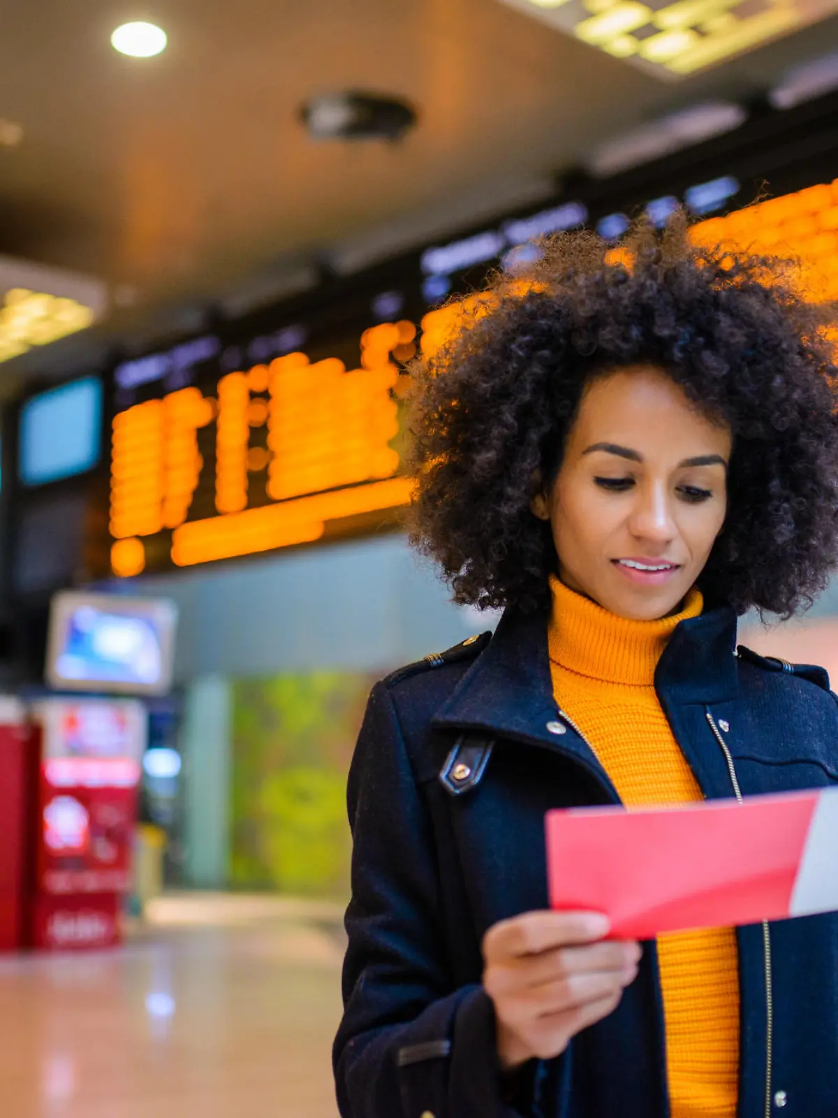 Frau am Flughafen sieht auf ihr Ticket.
