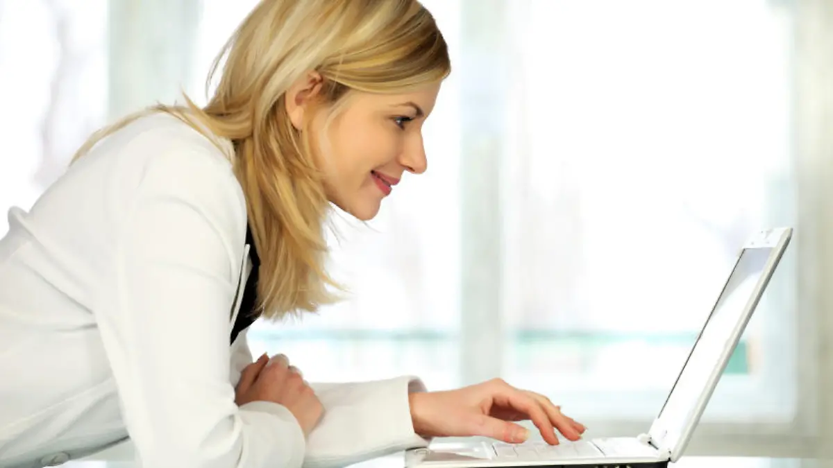 Woman typing on laptop computer.