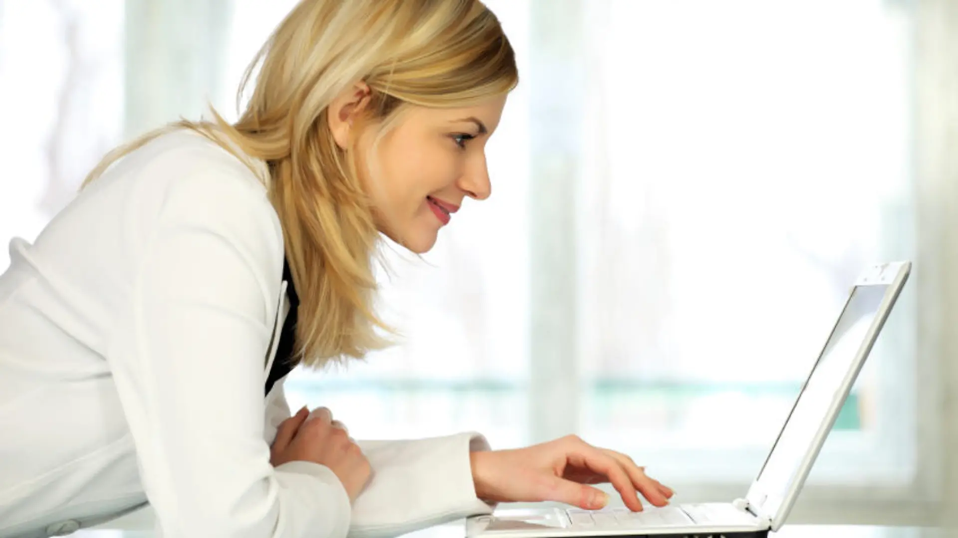 Woman typing on laptop computer.
