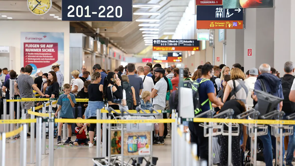 ARCHIV - 25.06.2022, Nordrhein-Westfalen, Köln: Passagiere stehen am Samstag Vormittag in einer Schlange von mehreren hundert Metern für die Sicherheitskontrolle am Flughafen Köln Bonn an. Kaum ist der Luftverkehr nach dem Streik wieder angelaufen, folgt der nächste Härtetest für Airlines und Passagiere. Mit dem Beginn der Osterferien startet die erste große Reisewelle des Jahres. (zu dpa «Nach dem Streik kommen die Ferien: Luftverkehr im Dauerstress») Foto: Thomas Banneyer/dpa +++ dpa-Bildfunk +++