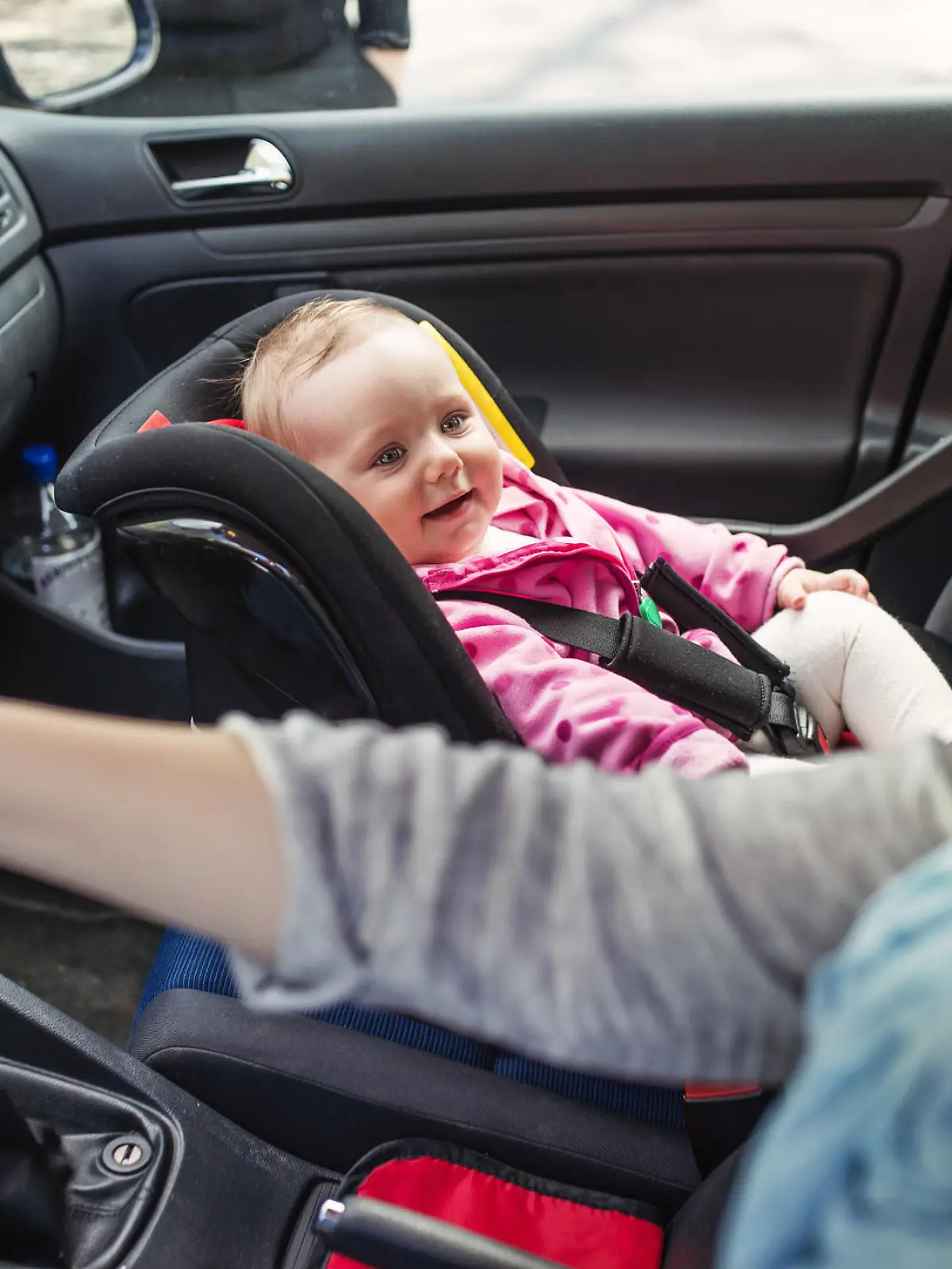 Mutter im Auto mit Baby im Kindersitz