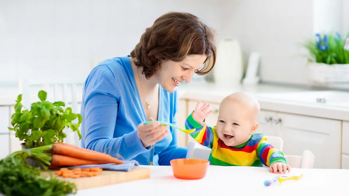 Tagesmutter füttert das Baby