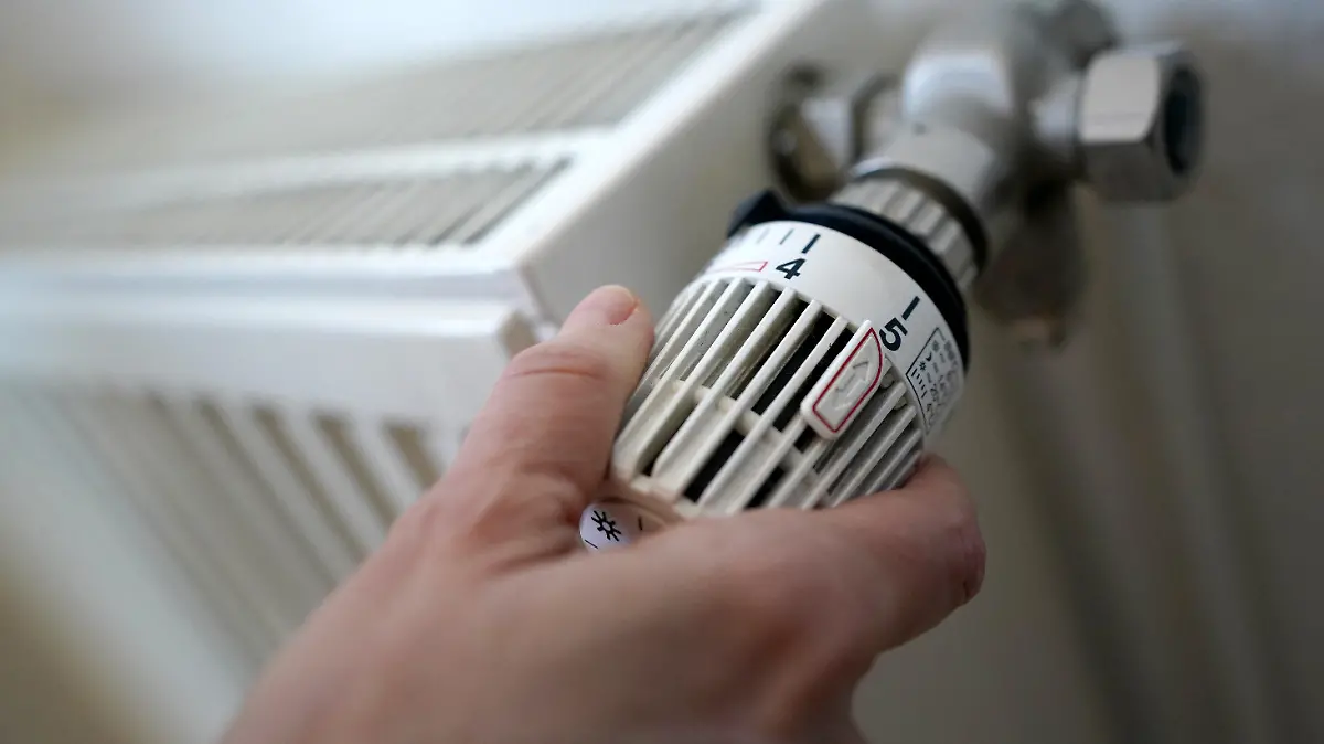ARCHIV - 09.03.2022, Hamburg: ILLUSTRATION - Eine Frau dreht an einem Heizungsthermostat. Beim vieldiskutierten Heizungstausch mahnt die Kommunalwirtschaft auch die Nutzung kommunaler Wärmepläne an. (zu dpa "VKU: Heizungstausch vorantreiben und parallel Wärmenetze ausbauen") Foto: Marcus Brandt/dpa +++ dpa-Bildfunk +++