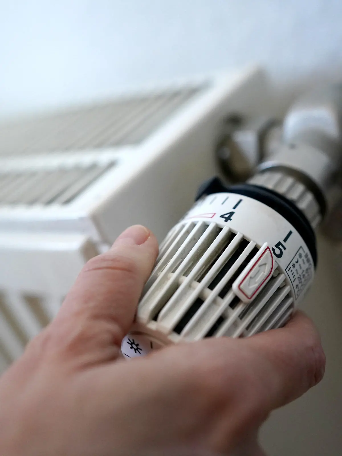 ARCHIV - 09.03.2022, Hamburg: ILLUSTRATION - Eine Frau dreht an einem Heizungsthermostat. Beim vieldiskutierten Heizungstausch mahnt die Kommunalwirtschaft auch die Nutzung kommunaler Wärmepläne an. (zu dpa "VKU: Heizungstausch vorantreiben und parallel Wärmenetze ausbauen") Foto: Marcus Brandt/dpa +++ dpa-Bildfunk +++