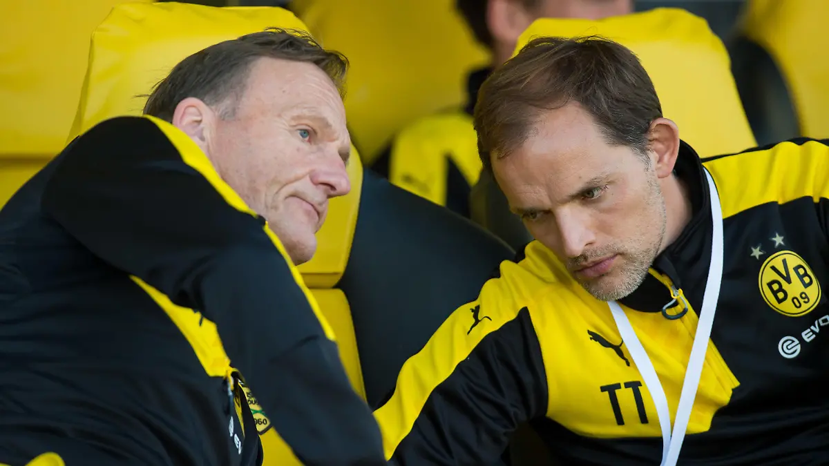 ARCHIV - 14.01.2016, Vereinigte Arabische Emirate, Dubai: Fußball, Testspiele, Jeonbuk Hyundai Motors FC - Borussia Dortmund am Freitag 15.01.2016 im Zabeel Stadion in Dubai (Vereinigte Arabische Emirate). Dortmunds Trainer Thomas Tuchel (r) sitzt vor dem Spiel auf der Trainerbank und unterhält sich mit Dortmunds Geschäftsführer Hans-Joachim Watzke (l). Laut Tuchel haben er und Watzke wieder ein normales Verhältnis zueinander. (zu dpa: «Tuchel vor Wiedersehen mit Watzke: Wogen geglättet») Foto: Guido Kirchner/dpa +++ dpa-Bildfunk +++
