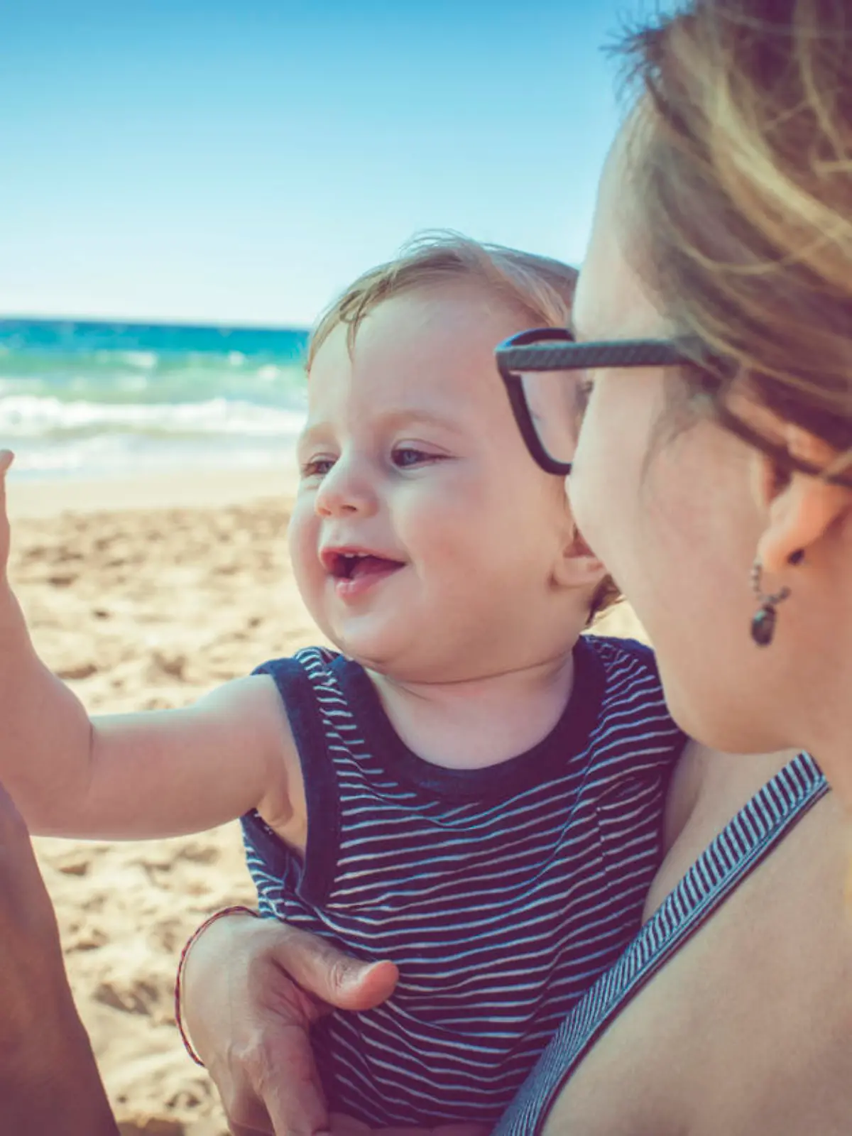 Kind und seine Mutter mit abgefülltem Wasser am Strand