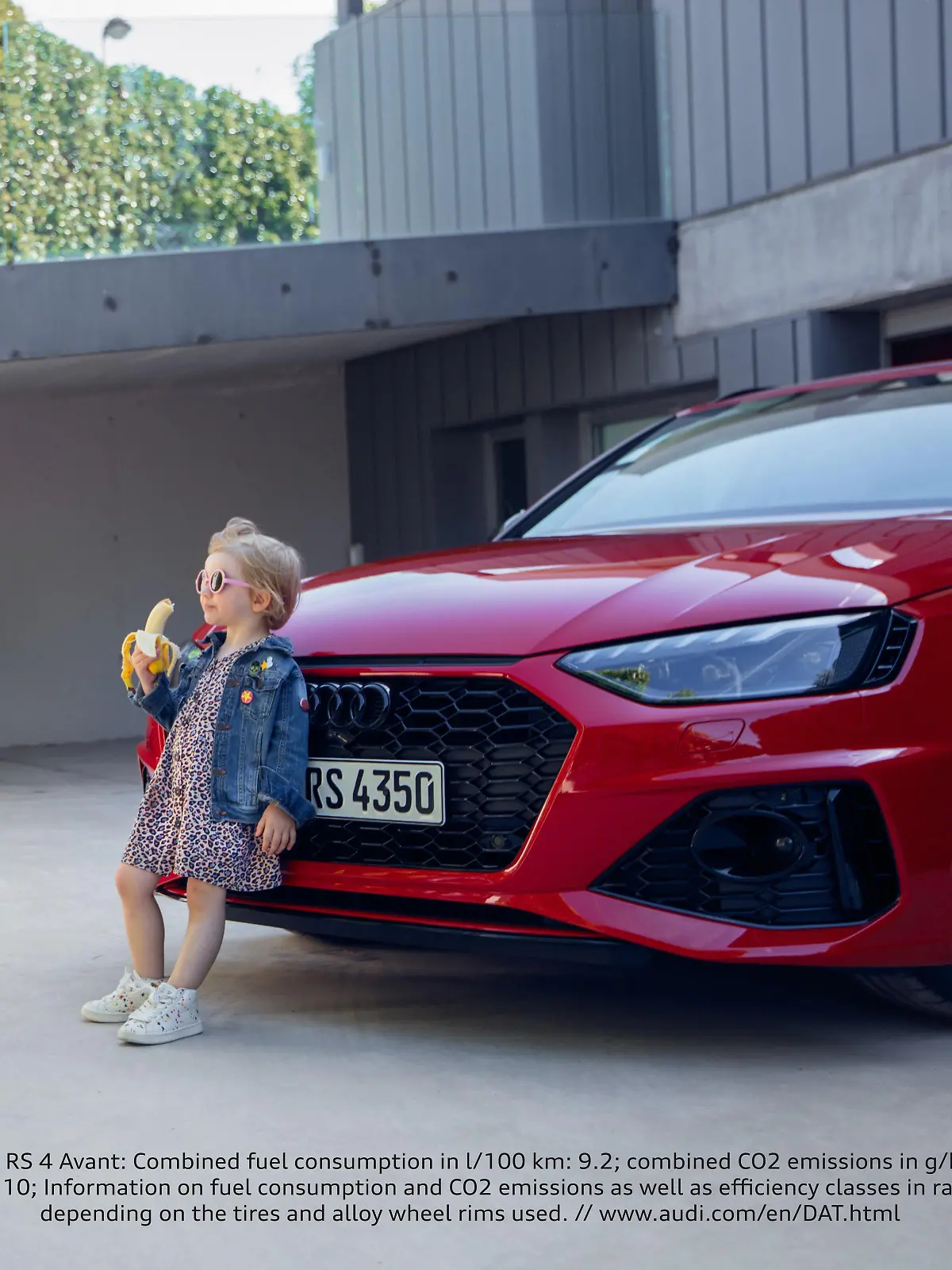 Audi-Werbekampagne: Ein kleines Mädchen steht, Banane-essend, vor dem Kühlergrill eines Autos.