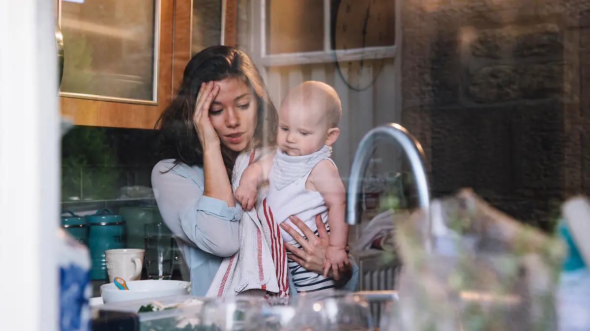 Gestresste Mutter zuhause mit dem Baby
