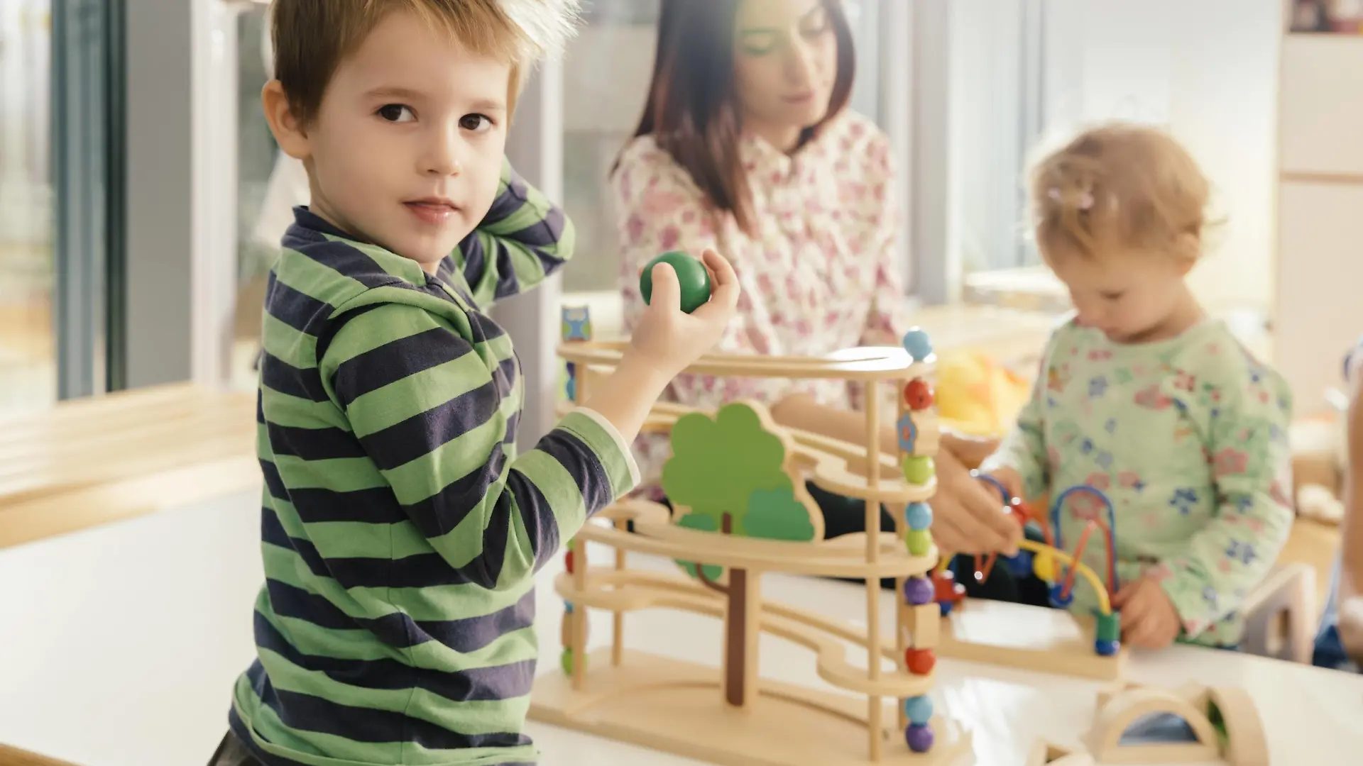 Boy looking up from playing with toys in kindergarten model released Symbolfoto property released PUBLICATIONxINxGERxSUIxAUTxHUNxONLY MFF04093