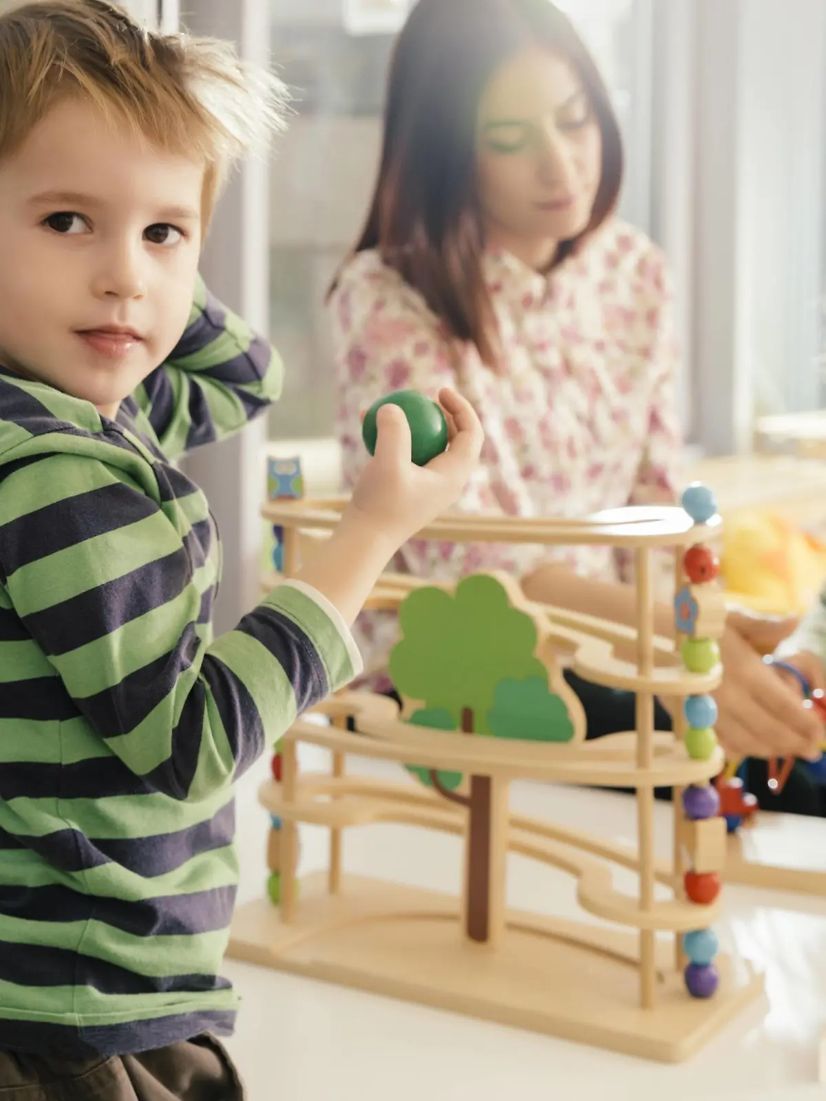 Boy looking up from playing with toys in kindergarten model released Symbolfoto property released PUBLICATIONxINxGERxSUIxAUTxHUNxONLY MFF04093  