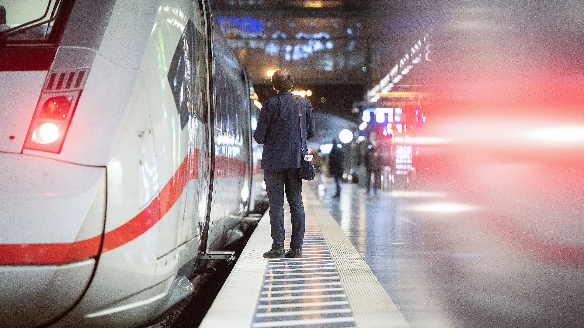 ARCHIV - 28.02.2023, Hessen, Frankfurt/Main: Ein Zugbegleiter steht am Hauptbahnhof an einem ICE. Nach einem schnell beendeten Tarifauftakt Ende Februar wollen sich die Deutsche Bahn und die Eisenbahn- und Verkehrsgewerkschaft (EVG) an diesem Dienstag erneut zusammensetzen. (zu dpa "Nächste Tarifrunde bei der Bahn - Warnstreiks drohen") Foto: Sebastian Gollnow/dpa +++ dpa-Bildfunk +++