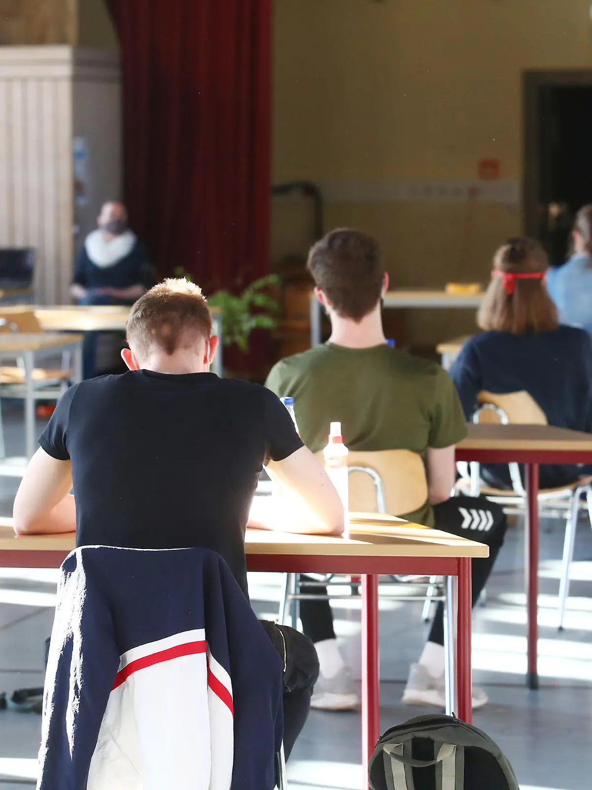 27.04.2020, Thüringen, Jena: Schüler mit Mundschutz sitzen bei der Prüfungsvorbereitung fürs Abitur in einer zum Schulraum umfunktionierten Turnhalle in der JenaPlan Schule. Nach einer mehrwöchigen Corona-Zwangspause öffnen die Schulen am 27.04.2020 wieder für die Abiturienten. Foto: Bodo Schackow/dpa-Zentralbild/dpa +++ dpa-Bildfunk +++