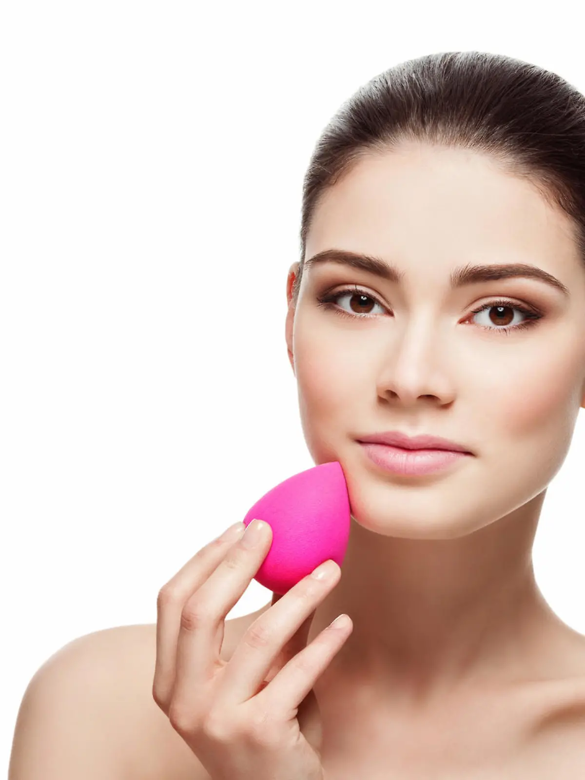 Beautiful young woman applying makeup using beauty blender sponge. Isolated over white background