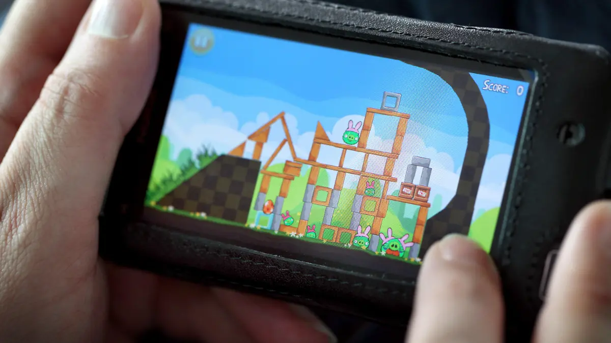 ARCHIV - Eine Frau spielt am 07.08.2011 auf ihrem Smartphone in Düsseldorf «Angry Birds». Die NSA und ihr britischer Partnerdienst GCHQ haben laut einem Zeitungsbericht auch Daten im Visier, die von Apps über die Nutzer gesammelt werden. Als ein Beispiel nannten die «New York Times» und der «Guardian» das populäre Spiel «Angry Birds». Foto: Martin Gerten /dpa (zu dpa "Neue Enthüllung: Geheimdienste zapfen App-Daten an" vom 28.01.2014) +++(c) dpa - Bildfunk+++