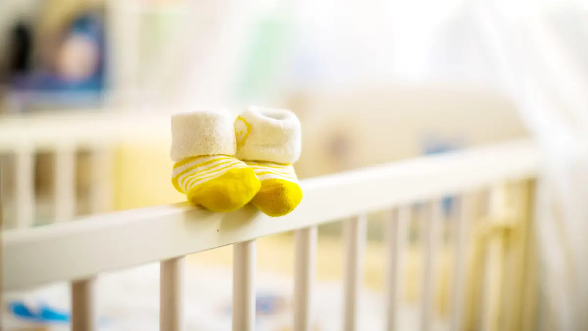 Leeres Babybett mit Socken