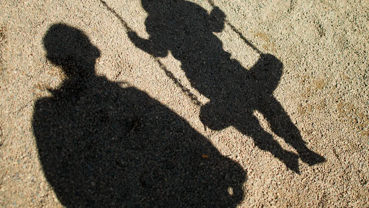 ARCHIV - ILLUSTRATION - Der Schatten von einem Mann und einem schaukelnden Kind fallen am 27.08.2014 auf Sand auf einem Spielplatz in Braunschweig (Niedersachsen). Foto: Julian Stratenschulte/dpa (zu dpa «Mann soll Jugendliche missbraucht haben - Neonazi als Vermittler» vom 05.11.2014) +++(c) dpa - Bildfunk+++
