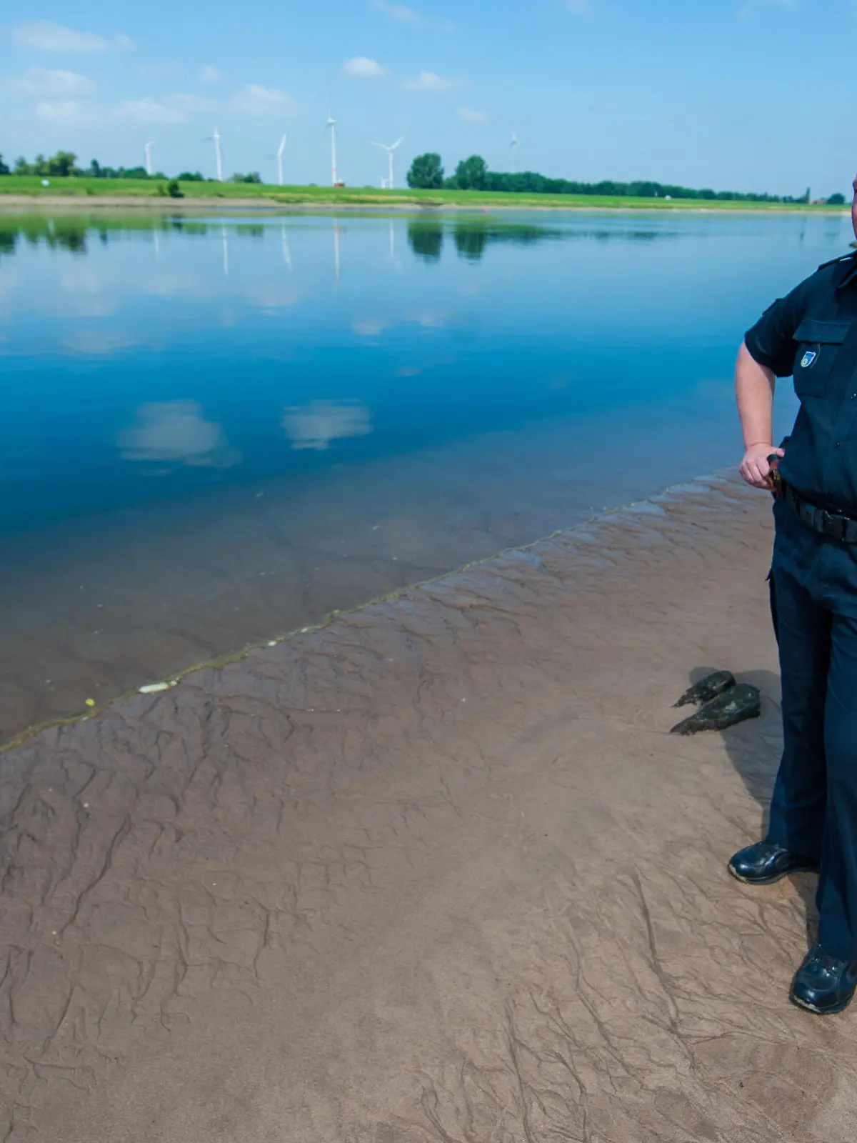 26.06.2018, Niedersachsen, Drage: Jan Krüger, Polizeisprecher, steht am Elbstrand bei Drage. Die Familie aus dem kleinen Ort an der Elbe verschwindet spurlos. Wenig später wird der Vater tot aus dem Fluss gezogen, seine Ehefrau und die zwölfjährige Tochter bleiben vermisst. Auch für erfahrene Polizisten bleibt der Fall etwas Besonderes, auch drei Jahre später. (zu dpa "Drage - zwei Menschen verschwinden spurlos" vom 08.07.2018) Foto: Philipp Schulze/dpa | Verwendung weltweit
