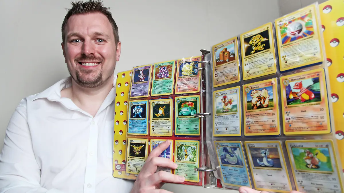 Nigel Brookes hält stolz seine Pokémon-Sammlung in der Hand.