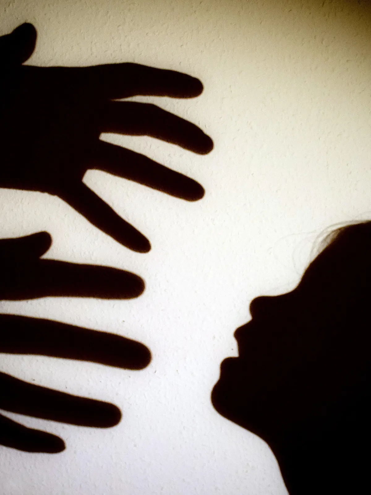ARCHIV - ILLUSTRATION - Schatten von Händen einer erwachsenen Person und dem Kopf eines Kindes an einer Wand eines Zimmers am 12.01.2014 in Frankfurt (Oder) (Brandenburg). (zu dpa «Studie zu Erfahrungen von Kindern mit sexueller Gewalt» vom 08.06.2017) Foto: Patrick Pleul/dpa-Zentralbild/dpa +++(c) dpa - Bildfunk+++
